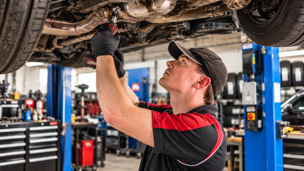 Mechanic working under a hoisted vehicle at Newcastle Automotive Services